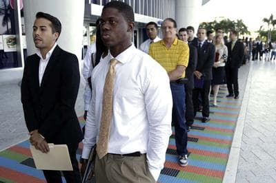 In this Wednesday, Oct. 23, 2013 file photo, Luis Mendez, 23, left, and Maurice Mike, 23, wait in line at a job fair held by the Miami Marlins, at Marlins Park in Miami. Increasingly, potential employers are turning to digital content as a way to judge job-seekers before they even apply. (AP)