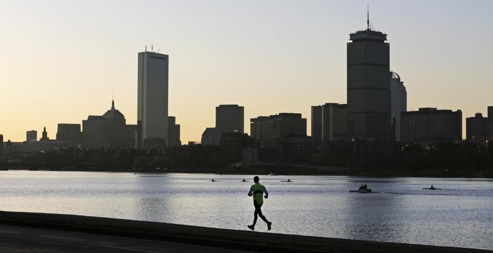 A solitary runner heads down the banks of the Charles River in Cambridge, Mass., in front of the Boston skyline, at dawn the morning after explosions killed three and injured more than 140 at the Boston Marathon, Tuesday, April 16, 2013.  (AP/Charles Krupa)