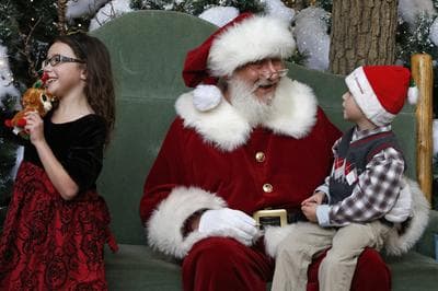 Santa chats with Asher Powell, age 6, while Asher's sister Alexis smiles during a visit to Santa's Wonderland House inside Flatirons Crossing Mall, in Broomfield, Colo., Wednesday, Dec. 18, 2013. (AP)