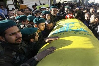 Hezbollah fighters, left, mourn as they carry the coffin of their commander Ali Bazzi, who was killed in Syria during a battle against the Syrian rebels, during his funeral procession, in the southern port city of Sidon, Lebanon, on Monday, Dec. 9, 2013. Hezbollah announced that two of its members, including a local commander, were killed while &quot;performing their jihadi duties.&quot; Syrian troops captured a western town near the country's main north-south highway on Monday as the government forged ahead with a punishing offensive in a mountainous region near the border with Lebanon, state media said. (AP)