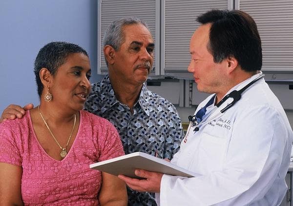 A Hispanic couple consult with an Asian doctor (National Cancer Institute via Wikimedia Commons)