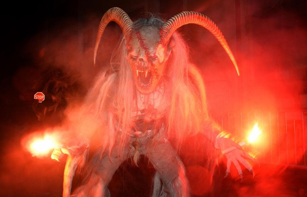 A man dressed as a Krampus, the companion of St. Nicholas and one of Austria's unique Christmas traditions, makes his way during a traditional Krampus procession in Lofer, the Austrian province of Salzburg, on Nov. 30, 2013. The Krampus is said to punish naughty children. (AP Photo/Kerstin Joensson)