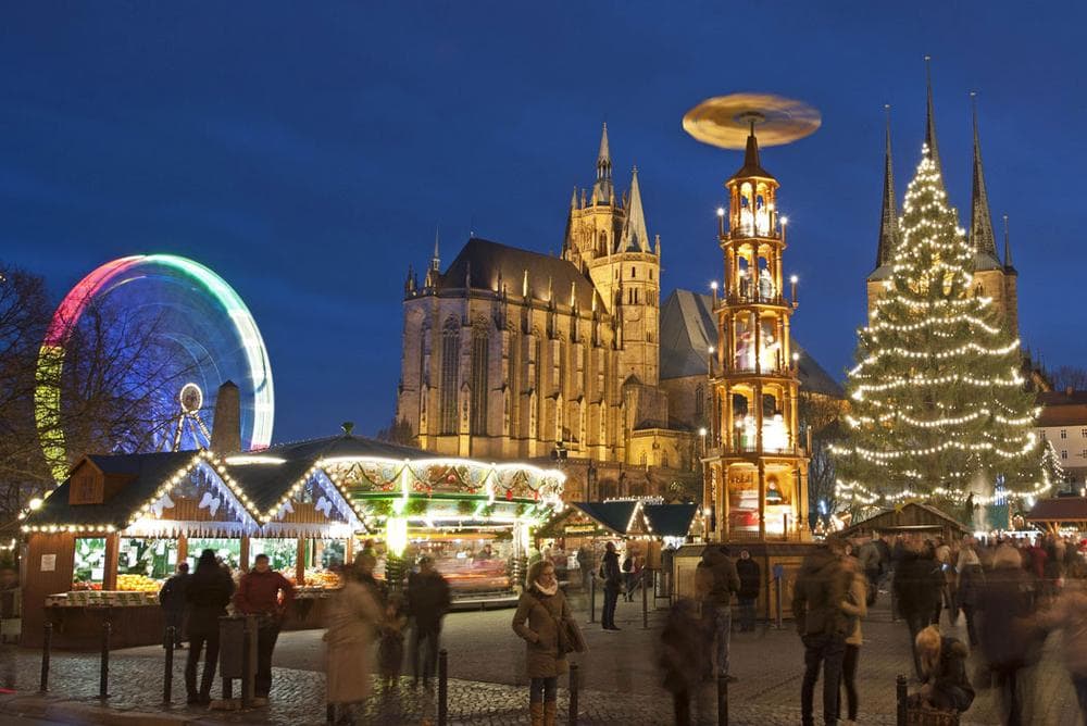 People walk along the Christmas Fair in front of the Mariendom (Cathedral of Mary) and St. Severi's Church in Erfurt, Germany, on Nov. 27, 2013. The Erfurt Christmas Market decorates the town’s square with a huge candle-lit Christmas tree and a large hand-carved wooden creche. (AP Photo/Jens Meyer)