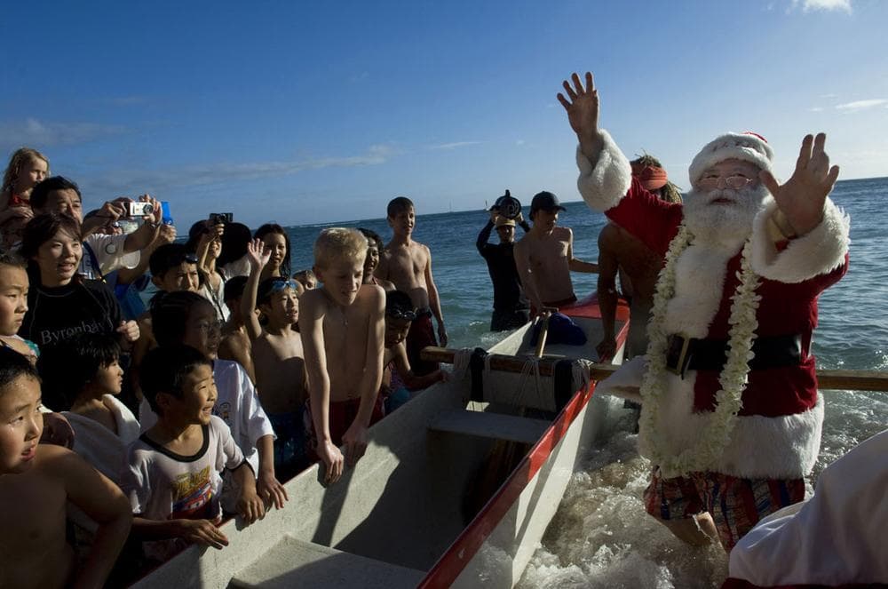 Santa Claus arrives by outrigger canoe at Waikiki in Honolulu, Hawaii, on Dec. 24, 2007. (AP Photo/Lucy Pemoni)