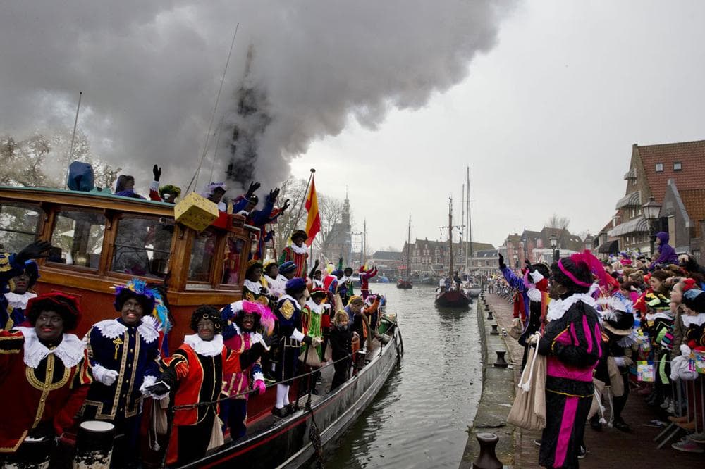 People dressed as &quot;Zwarte Piet&quot; or &quot;Black Pete,&quot; wave to spectators as they arrive by steamboat in Hoorn, Netherlands, on Nov. 16, 2013. (AP Photo/Peter Dejong)