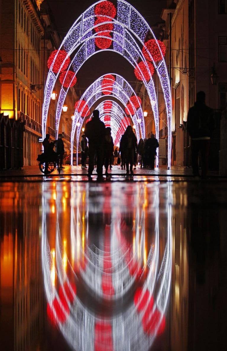 Christmas illuminations reflect on the ground in downtown Lisbon, Portugal, on Dec. 13, 2013. (AP Photo/Francisco Seco)