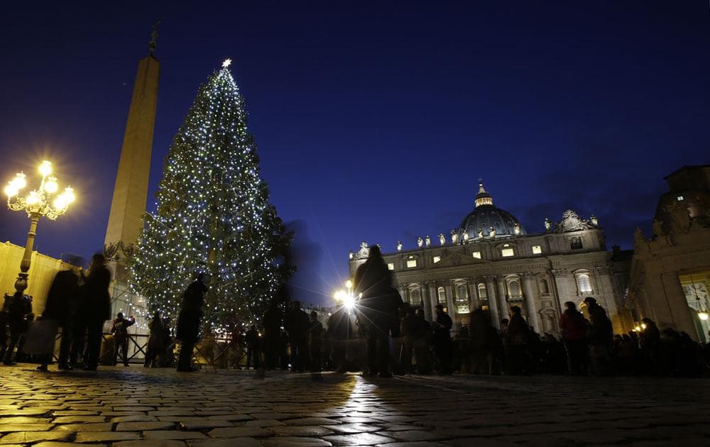 An 82-foot-tall Christmas tree from Bavaria, Germany, lights up St. Peter's Square, next to St. Peter's Basilica, at the Vatican, on Dec. 13, 2013. (AP Photo/Andrew Medichini) 