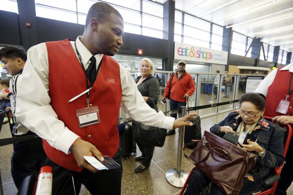 In this Tuesday, Oct. 22, 2013 photo, wheelchair attendant Erick Conley, left, assists an elderly passenger heading overseas at Seattle-Tacoma International Airport in SeaTac, Wash. (Elaine/Thompson/AP)