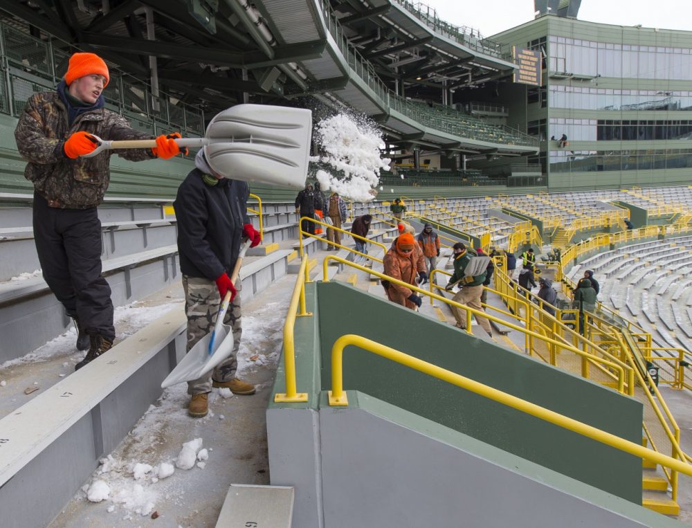 Workers clear ice and snow from the seats at Lambeau Field ahead of this Sunday's game. But, will anyone be willing to sit in them, as the forecast calls for one of the coldest games in history? (Mike Roemer/AP)