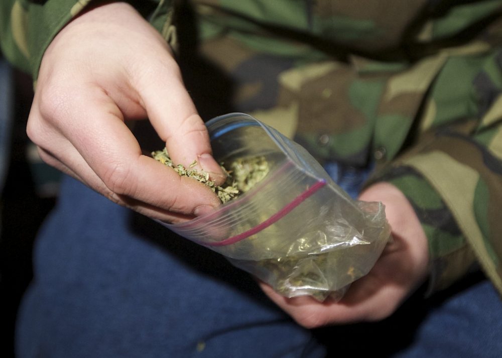 A Seattle resident takes marijuana from a plastic bag shortly after a law legalizing the recreational use of marijuana took effect on December 6, 2012 in Seattle, Washington. (Stephen Brashear/Getty Images)