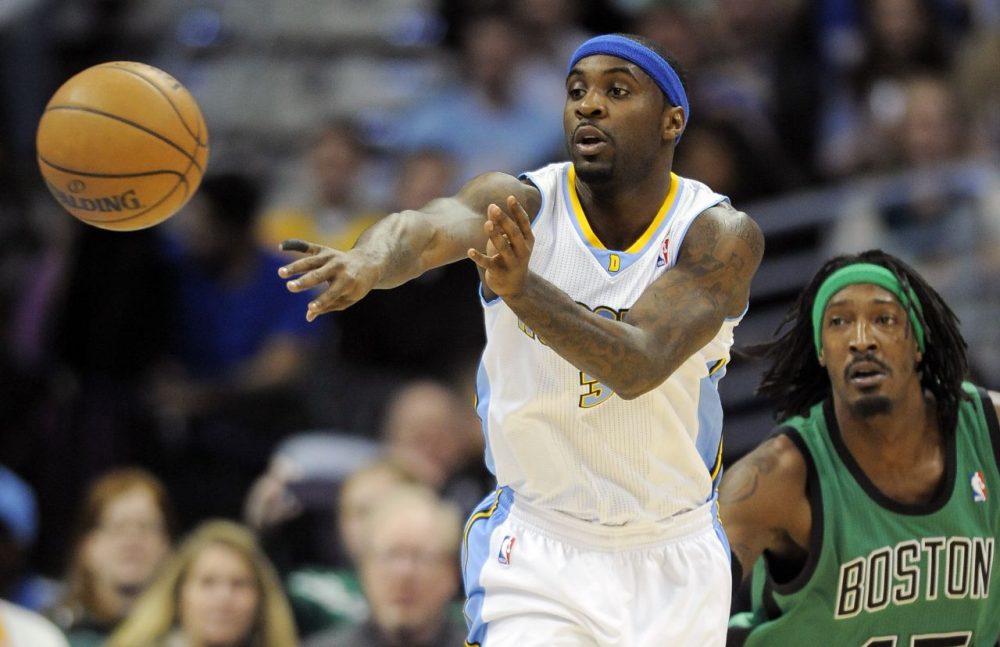 Denver Nuggets guard Ty Lawson passes the ball while being defended by Boston Celtics forward Gerald Wallace. (AP/Chris Schneider)