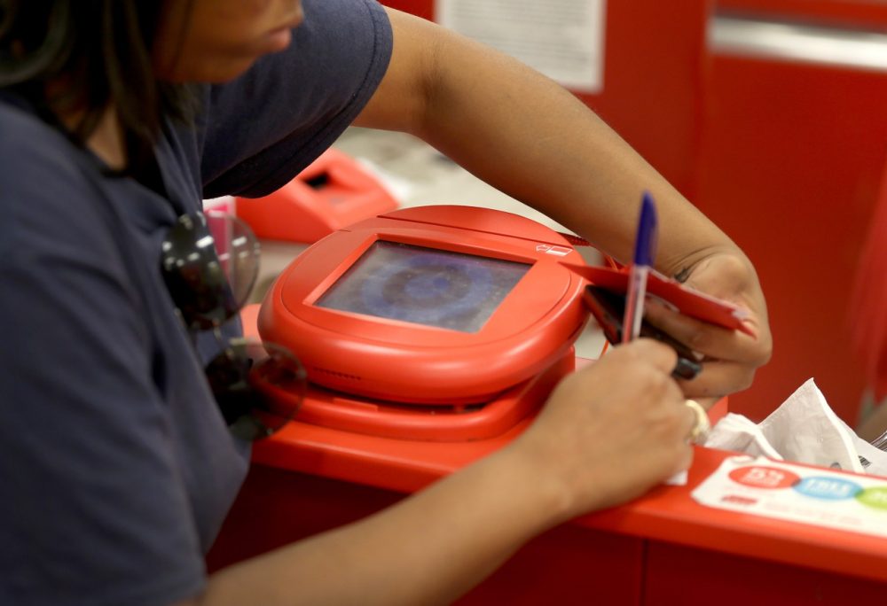 A customer signs a credit card statement next to a scanner in a Target store in Miami, Florida. The malicious computer tool used against the retailer in its massive credit card breach, called Kaptoxa, was revealed in a government report released January 16.  (Joe Raedle/Getty Images)