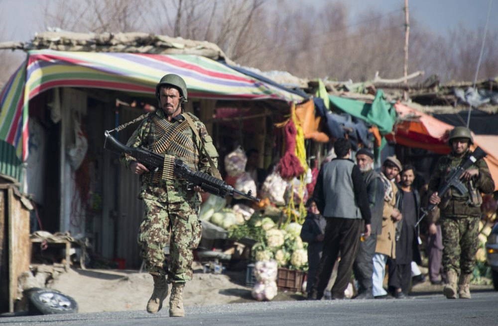 An Afghan National Army (ANA) soldier passes shops during an exercise in Poll-e-Matack, north of Kabul, on January 14, 2014.  (Johannes Eisele/AFP/Getty Images)