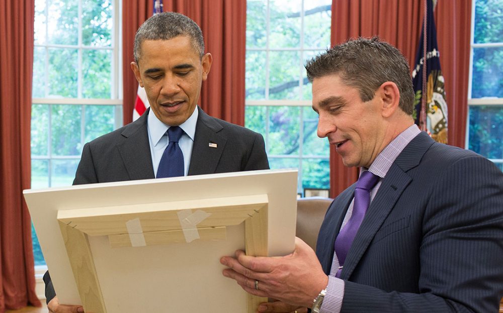 President Barack Obama and Richard Blanco look at a framed copy of &quot;One Today,&quot; in the Oval Office, May 20, 2013. (Official White House Photo by Pete Souza)