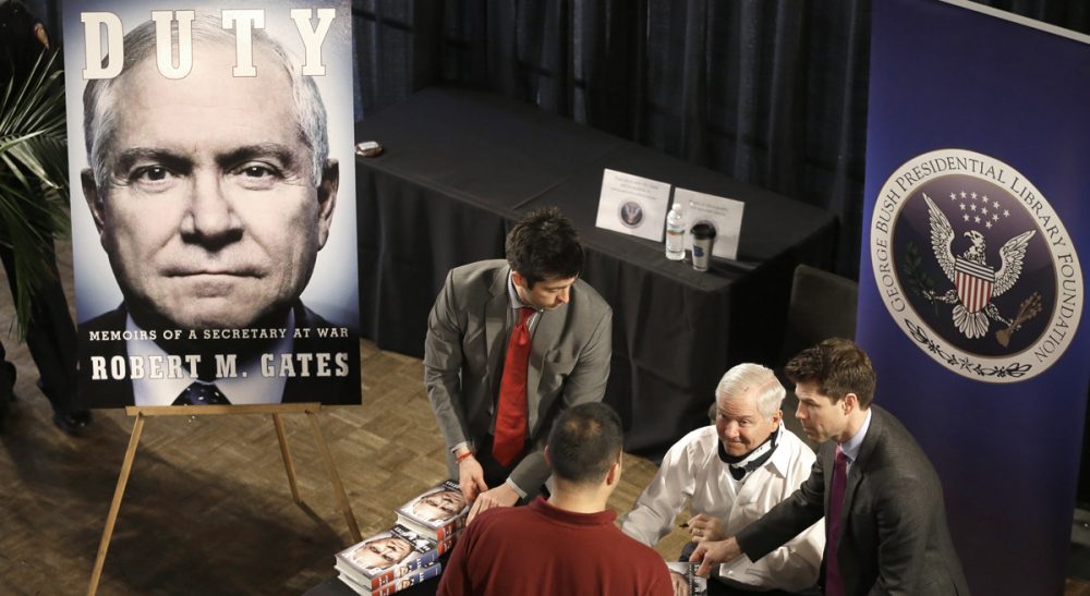 Over the course of four decades, former defense secretary Robert Gates had an enormous impact on U.S. national security. Based on a close reading of his new memoir, John Sivolella says it appears he might not be finished. 
In this photo, wearing a neck brace after a fall a few weeks ago, Gates, second from left, signs copies of his new book after speaking at Texas A&amp;M University Tuesday, Jan. 21, 2014, in College Station, Texas. (Pat Sullivan/AP)