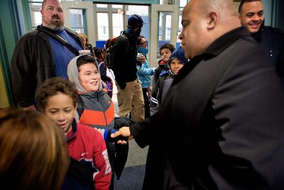 New Lawrence Mayor Daniel Rivera, right, greets students at dismissal from the Oliver School. (Jesse Costa/WBUR)