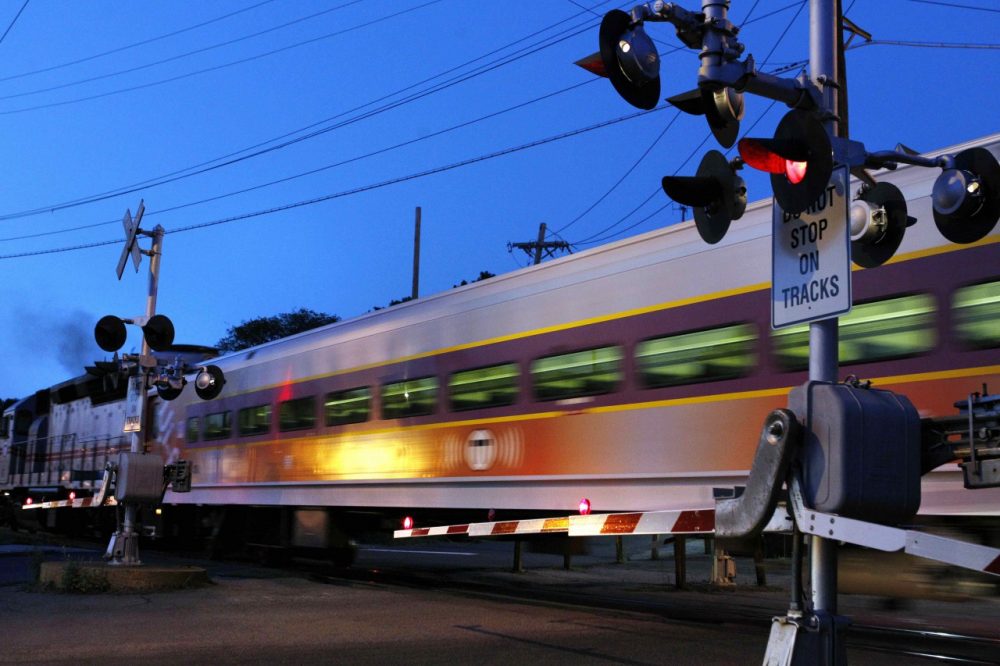 A commuter train passes crossing gates as it leaves the MBTA station in Andover, Mass. (AP)