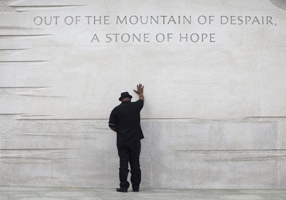 Rev. Bobby Turner or Columbus, Ohio, places his hand on the Martin Luther King Jr. Memorial, Thursday, Aug. 22, 2013, in Washington. (AP)