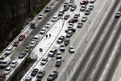 In this aerial view looking at I-75 north at Mt. Paran Rd., abandoned cars are piled up on the median of the ice-covered interstate after a winter snow storm Wednesday, Jan. 29, 2014, in Atlanta. Georgia Gov. Nathan Deal said early Wednesday that the National Guard was sending military Humvees onto Atlanta's snarled freeway system in an attempt to move stranded school buses and get food and water to people. Georgia State Patrol troopers headed to schools where children were hunkered down early Wednesday after spending the night there, and transportation crews continued to treat roads and bring gas to motorists, Deal said. (AP)