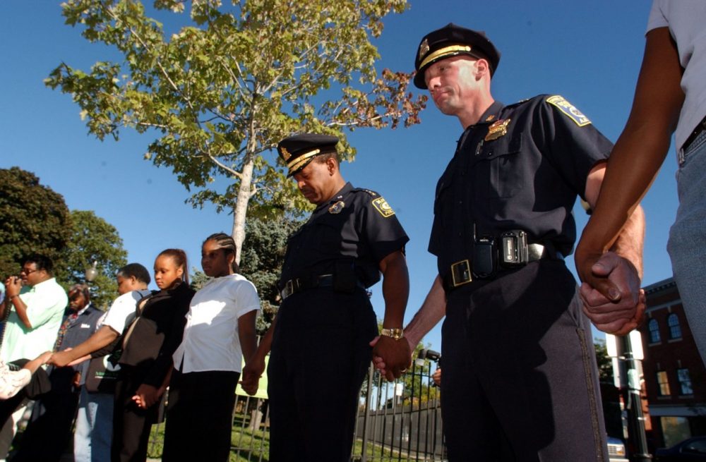 Massachusetts Bay Transportation Authority Chief Joseph Carter, center, and Boston police Superintendent of the Bureau of Investigative Services Paul Joyce, right, join hands in prayer, Sunday, Sept. 26, 2004 in the Dorchester neighborhood of Boston, for families that have lost youth to street violence.
