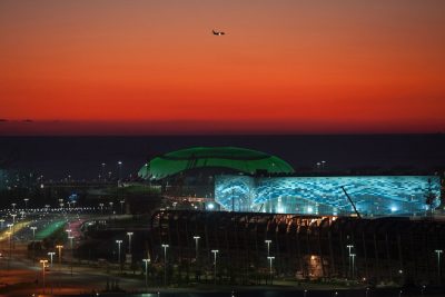 This Oct. 24, 2013 file photo shows the illuminated Olympic Bolshoy stadium, in the background, and Iceberg stadium, the location for figure skating and short track speed skating events during the 2014 Olympic Games, in the Olympic park in the coastal cluster in the Black Sea resort of Sochi, Russia. (AP)