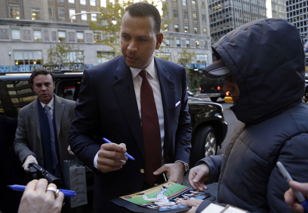 Alex Rodriguez signs autographs as he arrives at MLB headquarters in New York. (Seth Wenig/AP)