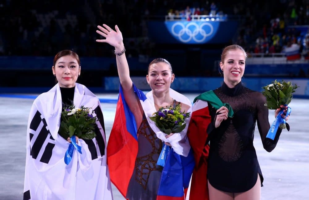 From left to right, silver medalist Yuna Kim of South Korea, gold medalist Adelina Sotnikova of Russia and bronze medalist Carolina Kostner of Italy celebrate during the flower ceremony for the Ladies' Figure Skating. (Ryan Pierse/Getty Images)