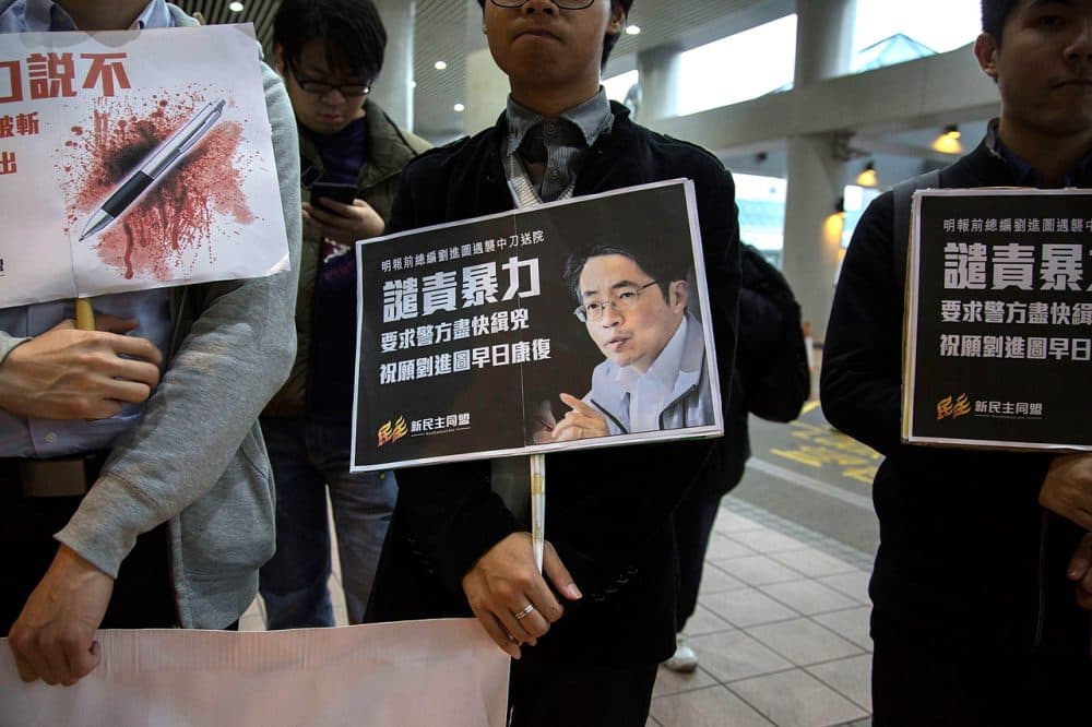 Pro-democracy activists hold a sign with an image of former chief editor of the Ming Pao daily Kevin Lau Chun-to as they attend a candlelight vigil at a hospital, to urge the police to solve the stabbing incident involving Lau, on February 26, 2014 in Hong Kong. (Lam Yik Fei/Getty Images)