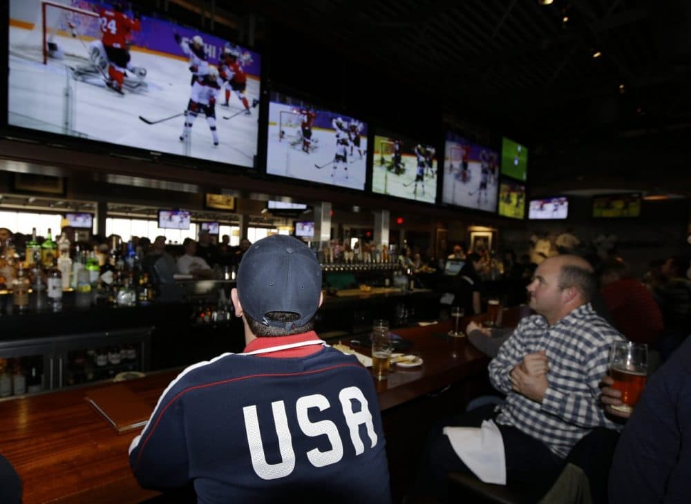 Jason Bryer, left, and Jeremy Pafundi watches the USA play Canada in a Sochi Olympics semifinal match at the Cask 'n Flagon Restaurant and Sports Bar in Marshfield, Mass., Friday, Feb. 21, 2014. (AP)