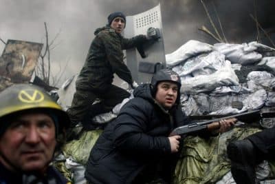 An anti-government protester holds a firearm as he mans a barricade on the outskirts of Independence Square in Kiev, Ukraine, Thursday, Feb. 20, 2014. Fierce clashes between police and protesters, some including gunfire, shattered a brief truce in Ukraine's besieged capital Thursday, killing numerous people. (AP)