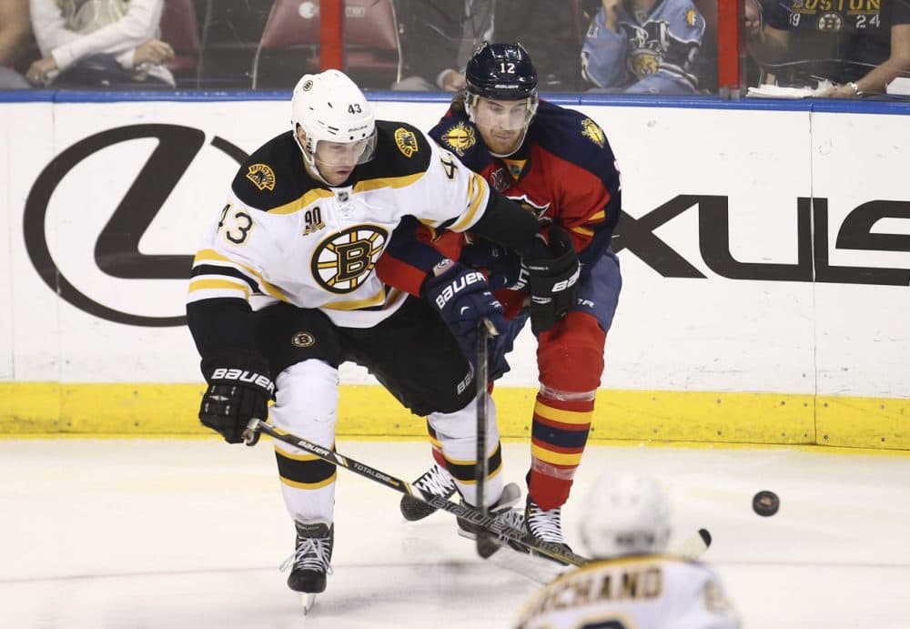 Boston Bruins' Matt Bartkowski (43) and Florida Panthers' Jimmy Hayes (12) chase the puck. (AP/J Pat Carter)