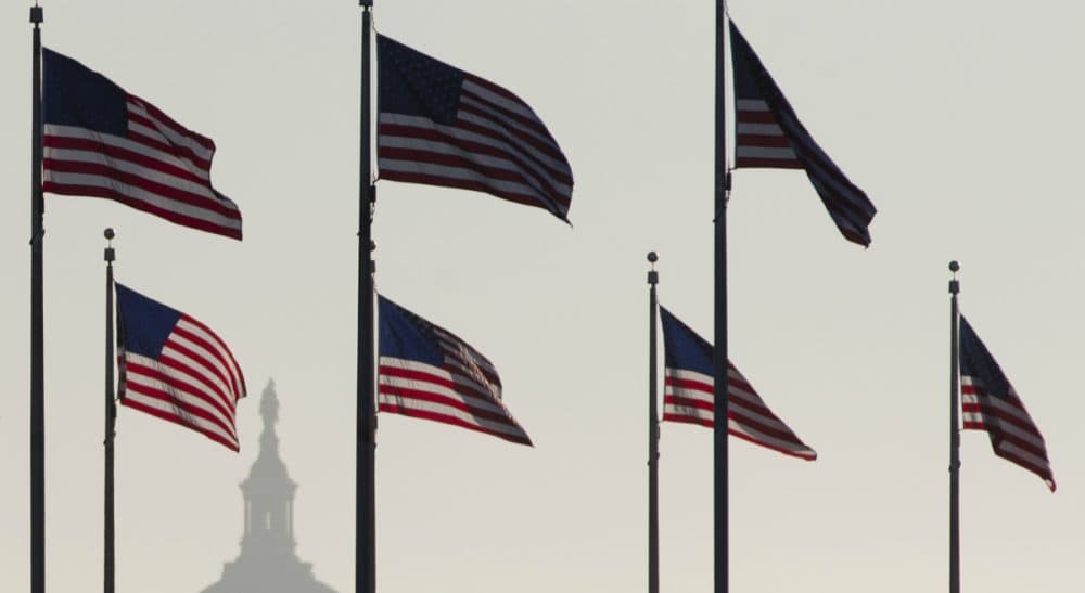 The U.S. Capitol Dome is seen in the distance as American flags fly on the National Mall around the base of the Washington Monument, Tuesday, Oct. 15, 2013, in Washington. (Carolyn Kaster/AP)