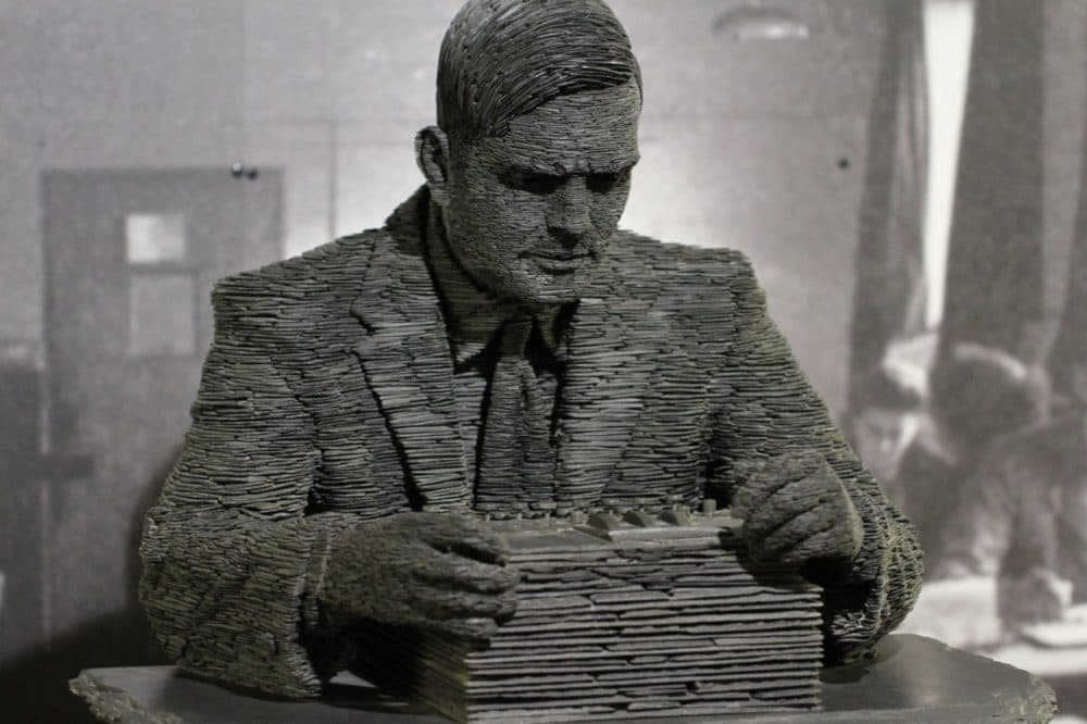 A statue of Alan Turing at the Bletchley Park Museum, poring over an Enigma machine. (Duane Wessels/Flickr)