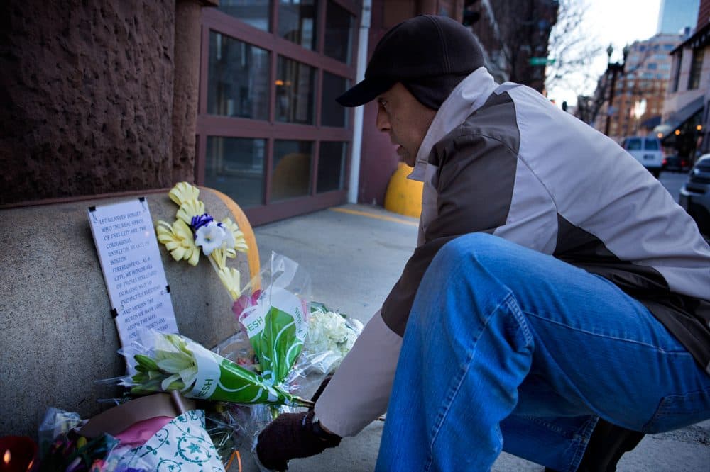 Michael Morrison, who&#8217;s up from Martha&#8217;s Vineyard getting cancer treatment in Boston, visits a makeshift memorial at the Engine 33 fire station on Thursday. Engine 33 was the station of fallen firefighters Lt. Edward Walsh and Michael Kennedy. 