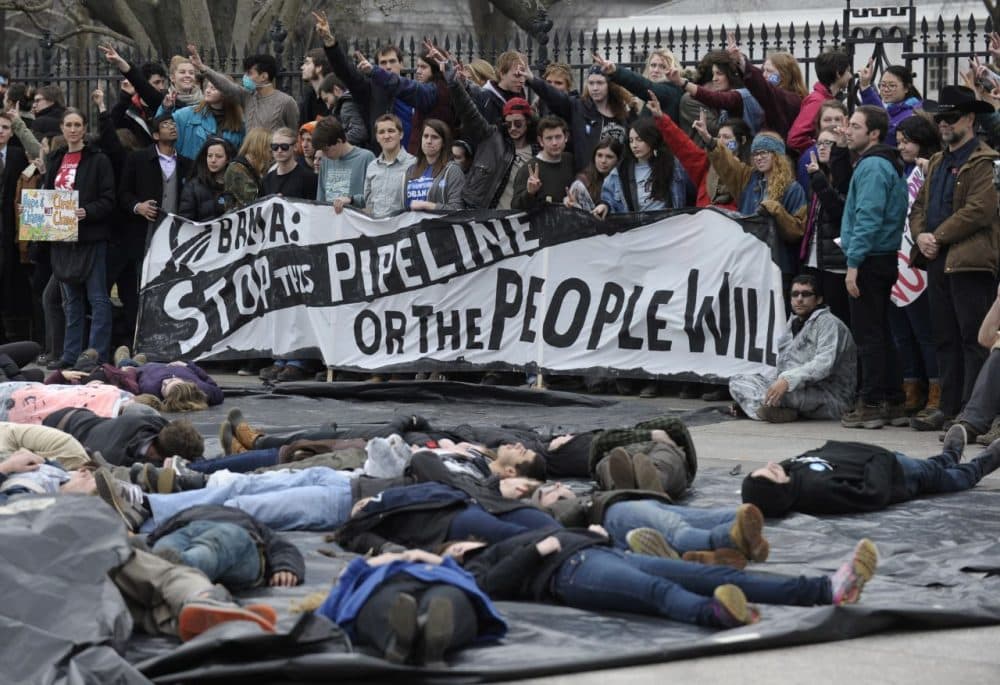 Several hundred students and youth who marched from Georgetown University to the White House to protest the Keystone XL Pipeline wait to be arrested outside the White House in Washington, Sunday, March 2, 2014. (Susan Walsh/AP)