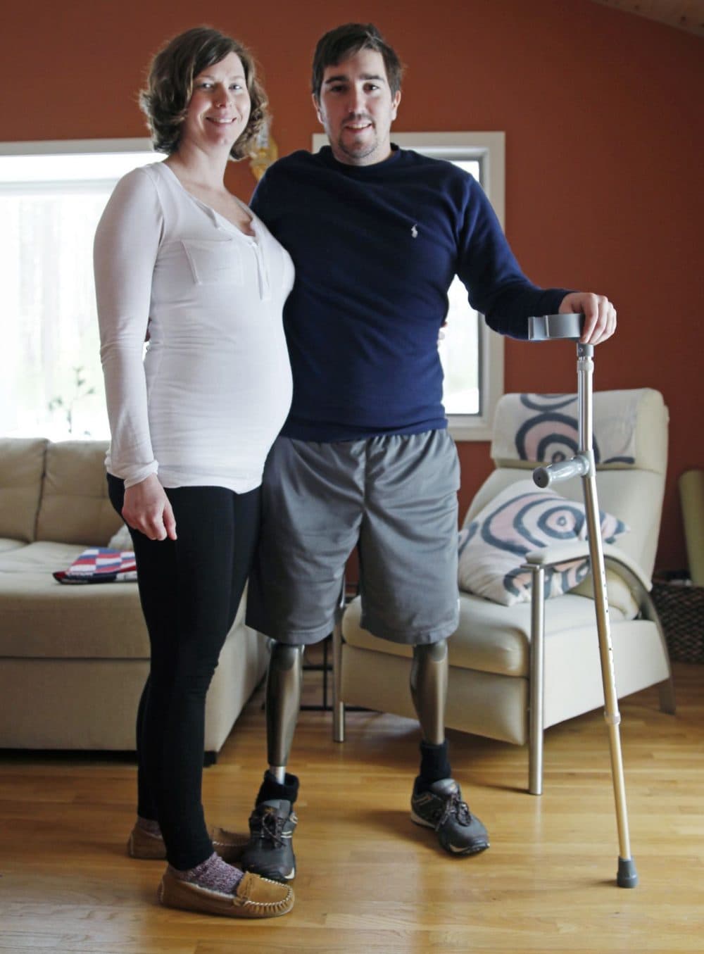 Jeff Bauman, who lost both legs in the Boston Marathon bombings, then helped authorities identify the suspects, poses with his expectant fiancé, Erin Hurley, their home in Carlisle, Mass., Friday, March 14, 2014. According to Bauman, the baby is due July 14. They don’t know if it’s a boy or a girl, and they want it to be a surprise. The two were engaged in February. (Charles Krupa/AP)