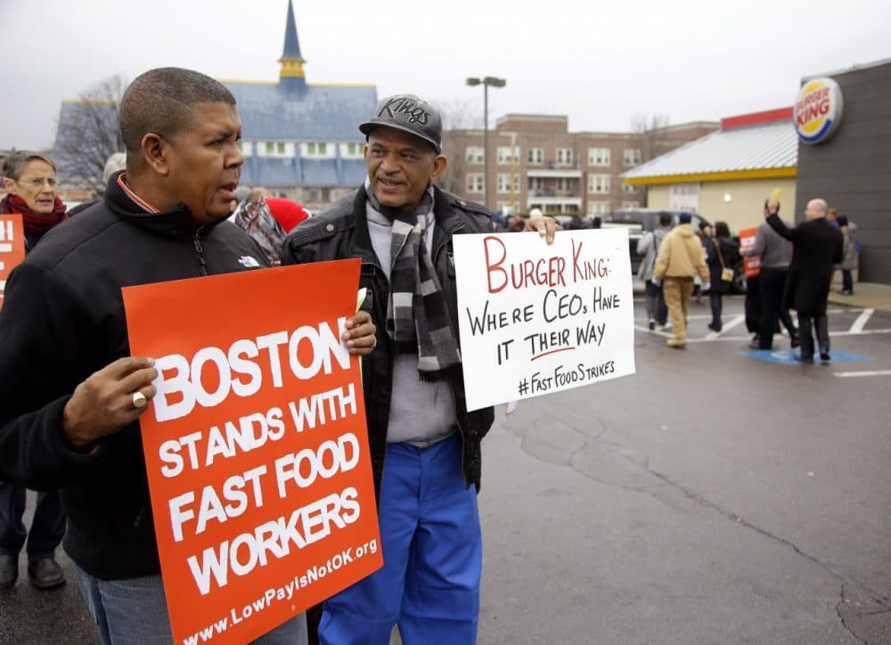 Pedro Rodriguez, right, and Andrus Reyes participate in a demonstration on a Burger King parking lot as part of a nationwide protest supporting higher wages for workers in the fast-food industry and other minimum wage jobs in Boston, Dec. 5, 2013. (AP/Stephan Savoia)