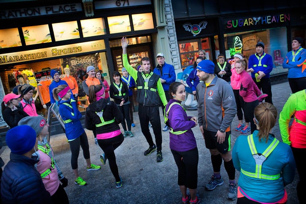 Marathon Sports manager Shane O’Hara gathers members of the store’s running group on Boylston Street before they head out on their weekly Wednesday night run.  (Jesse Costa/WBUR)
