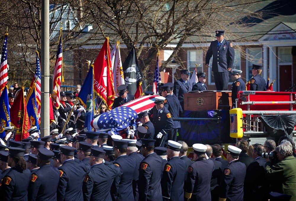 Firefighter Michael Kennedy's casket is carried off a fire truck and toward West Roxbury's Holy Name Church on Thursday. (Jesse Costa/WBUR)