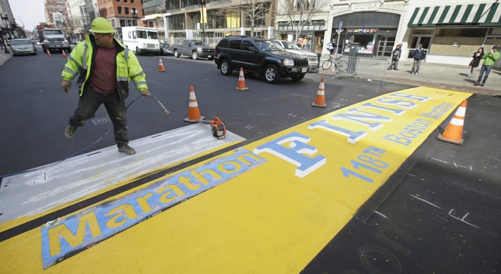 In this photo, Eric House applies a fresh coat of paint to the Boston Marathon finish line on Boylston Street in Boston, Tuesday, March 25, 2014. The 118th running of the Boston Marathon will occur on April 21, 2014. (Stephan Savoia/AP)
