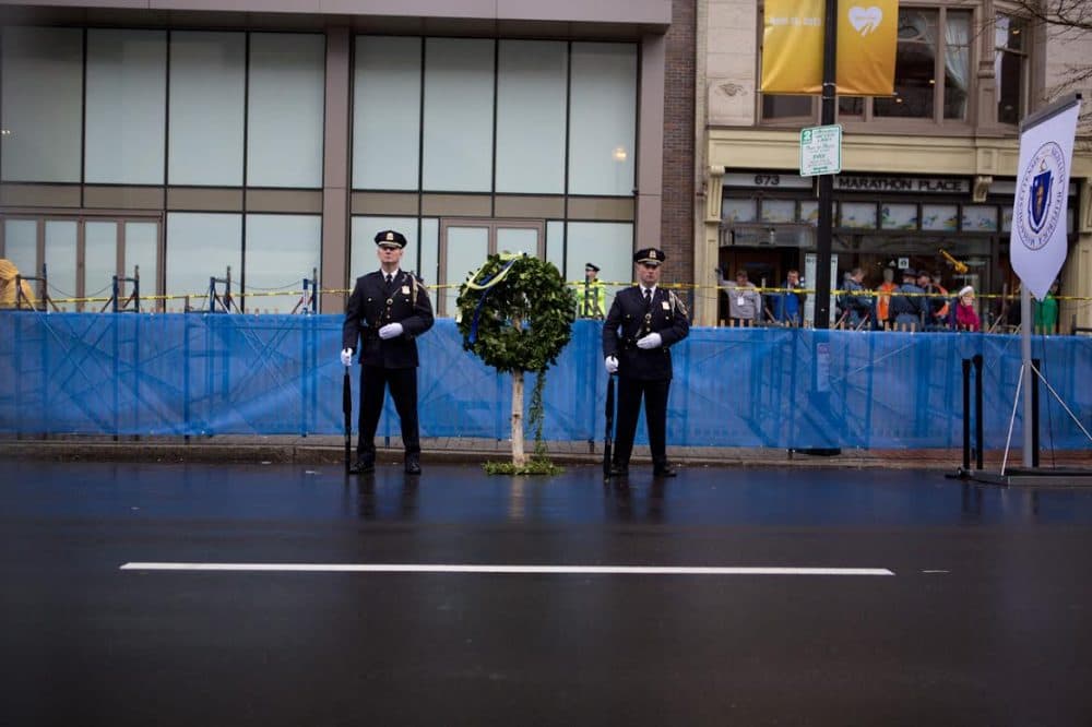 A Boston Police honor guard is posted outside Marathon Sports, the site of the first explosion at last year’s Boston Marathon. (Jesse Costa/WBUR)