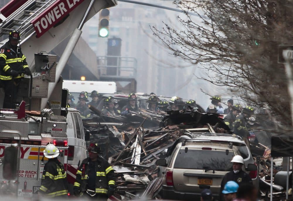 Firefighters continue to investigate and remove debris from an explosion in Harlem, Wednesday, March 12, 2014 in New York. A gas leak triggered an explosion that shattered windows a block away. (Bebeto Matthews/AP)