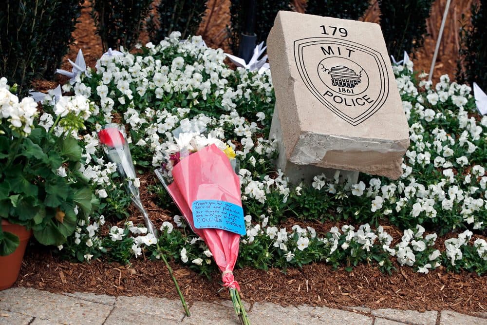 Flowers lay at a memorial stone after a one-year remembrance ceremony for Massachusetts Institute of Technology Officer Sean Collier on campus in Cambridge Friday. (Elise Amendola/AP)