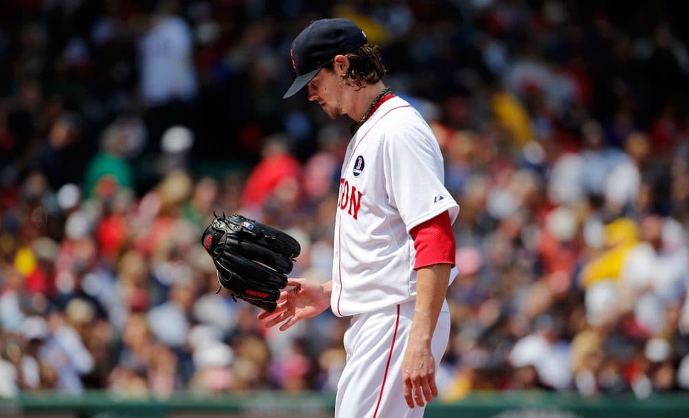 Red Sox starter Clay Buchholz flips his glove after being pulled from the game after he gave up six runs to the Orioles Monday. (Winslow Townson/AP)