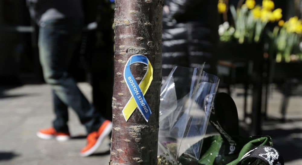 Social critic Wendy Kaminer says, for better or worse, the Boston Marathon is no longer an athletic event -- it's an icon. In this photo, a patron enters the Forum restaurant, site of one of two bomb blasts during the 2013 Marathon, while passing a &quot;Boston Strong&quot; sticker adhered to a tree trunk at a makeshift memorial on Boylston Street. Wednesday, April 16, 2014 in Boston. (Charles Krupa/AP)