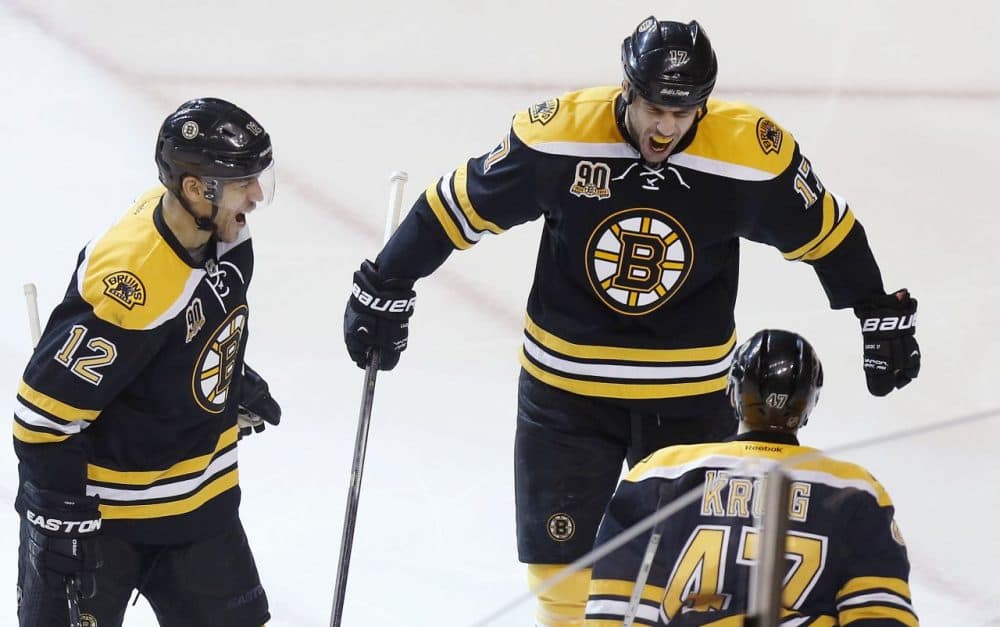 Bruins' Milan Lucic, top right, celebrates his goal with teammates Jarome Iginla and Torey Krug during the third period. (Michael Dwyer/AP)