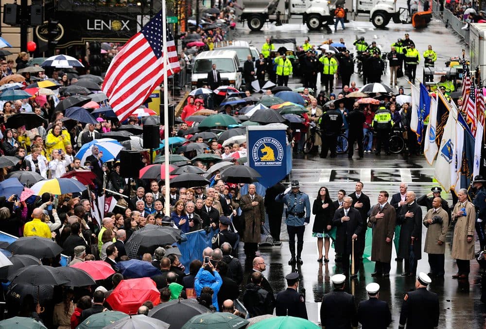 urvivors, officials, first responders and guests pause as the flag is raised at the finish line during a tribute in honor of the one year anniversary of the Boston Marathon bombings. (Charles Krupa/AP