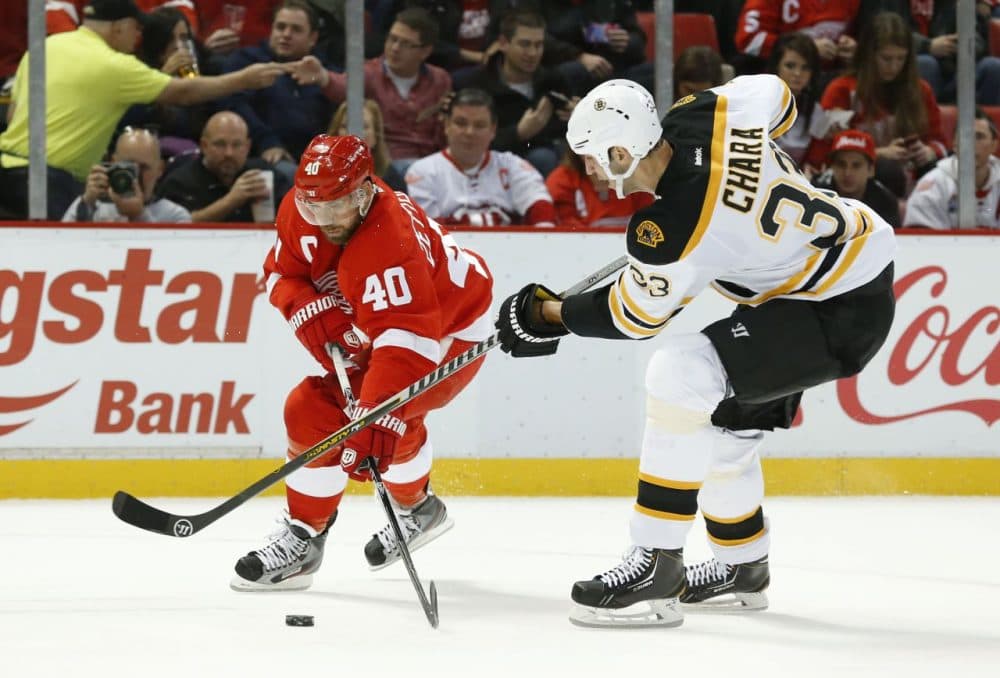 Detroit Red Wings left wing Henrik Zetterberg (40), of Sweden, and Boston Bruins defenseman Zdeno Chara (33), of the Czech Republic, battle for the puck in the second period of an NHL hockey game in Detroit Wednesday, Nov. 27, 2013. (Paul Sancya/AP)
