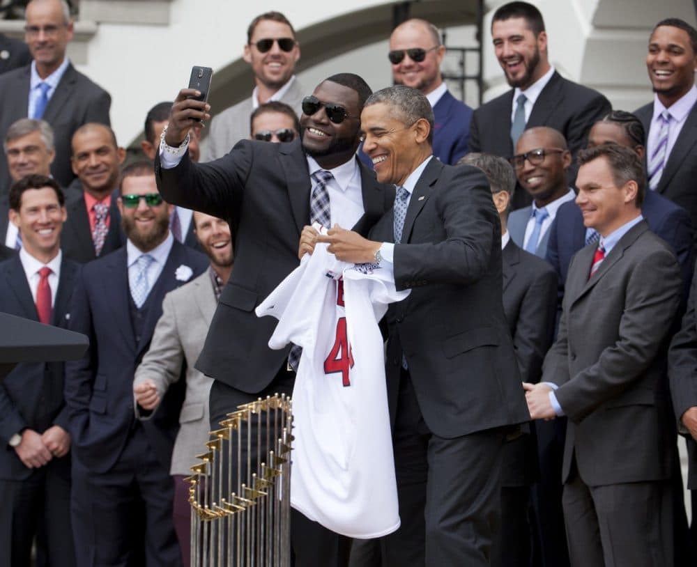 Boston Red Sox designated hitter David &quot;Big Papi&quot; Ortiz, left, takes a selfie with President Barack Obama, holding a Boston Red Sox jersey presented to the president during a ceremony on the South Lawn of the White House in Washington, Tuesday, April 1, 2014, where the president honored the 2013 World Series baseball champion Boston Red Sox. (AP)