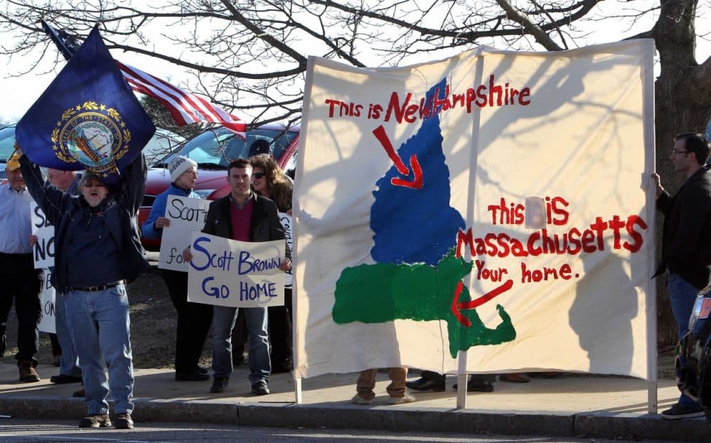 Protesters rally across the street from the hotel where former Massachusetts U.S. Sen. Scott Brown is scheduled to appear, Thursday, April 10, 2014, in Portsmouth, N.H. Brown is expected to announce his plans to seek a U.S. Senate seat from New Hampshire, Thursday. (AP)